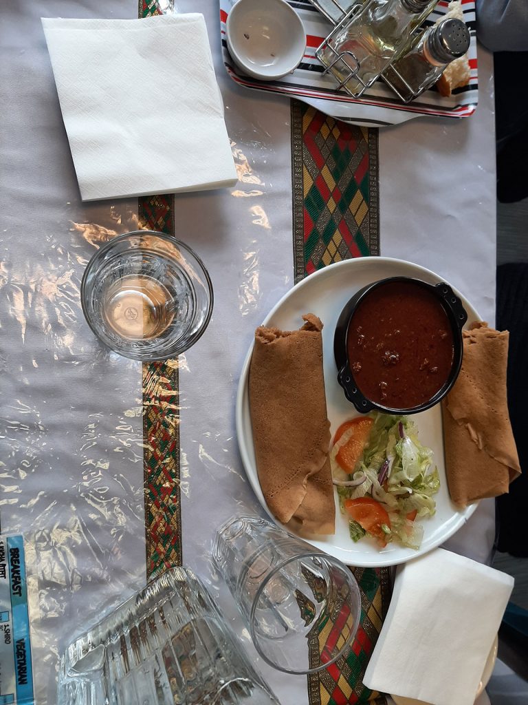 wat (pulse-based stews) dish including injera – a soft, spongy sourdough flatbread that resembles thick pancakes.