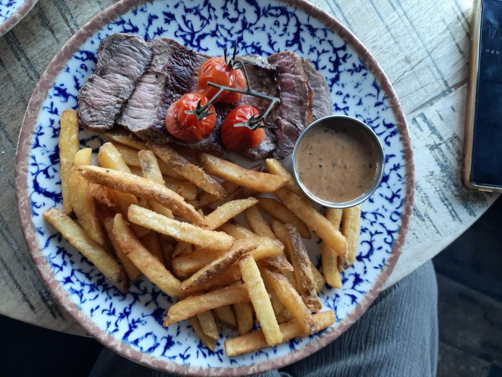 Steak Frites. This included a 28-day aged 6oz sirloin steak, fries, vine tomatoes, and peppercorn sauce at the Gin & Juice Mumbles Swansea