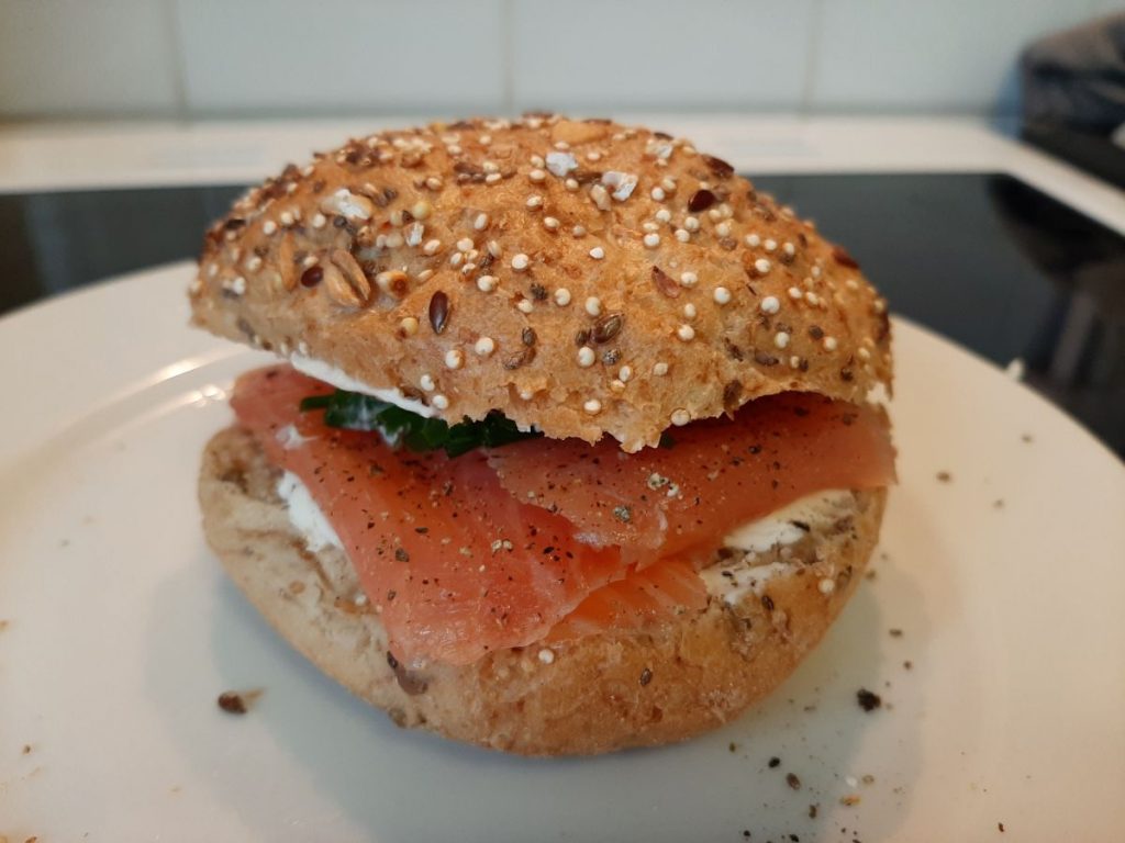 Yn barod i'w fwyta: Eog mwg ffres gyda chaws meddal, cennin, pupur du wedi'i falu, a gwasgiad o lemwn. Rholyn Grawn Hynafol wedi'i bacio â hadau.