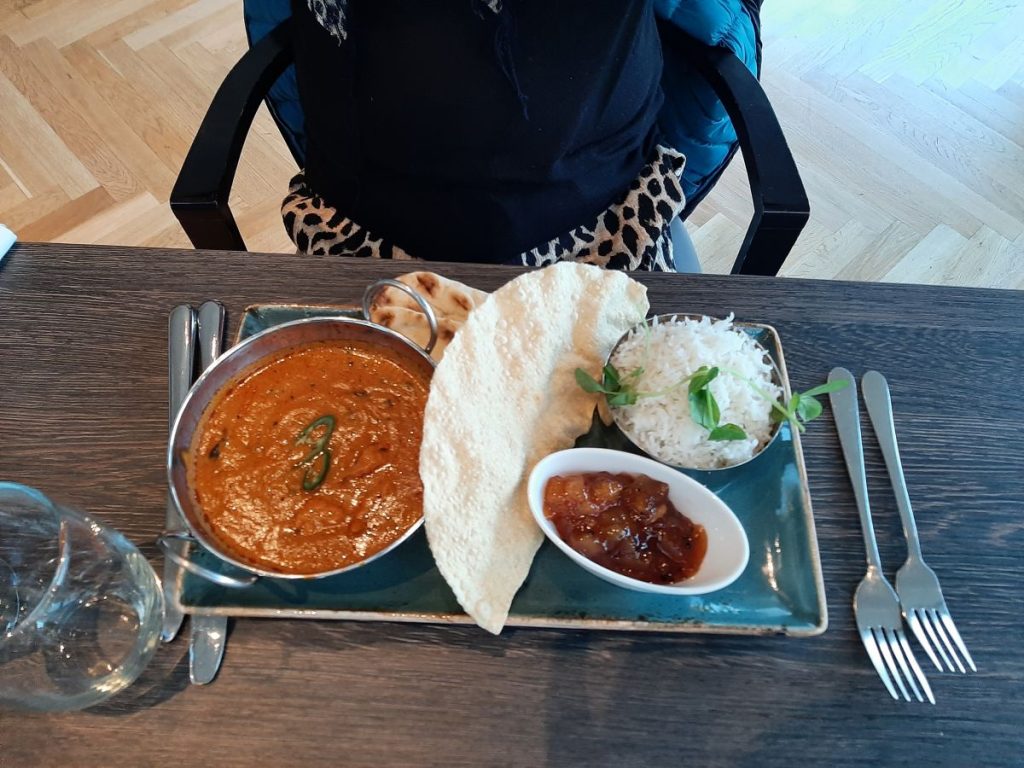 Chicken Murgh Makhani, served with basmati rice, sourdough naan, poppadom, and mango chutney at the Hilton London Wembley.