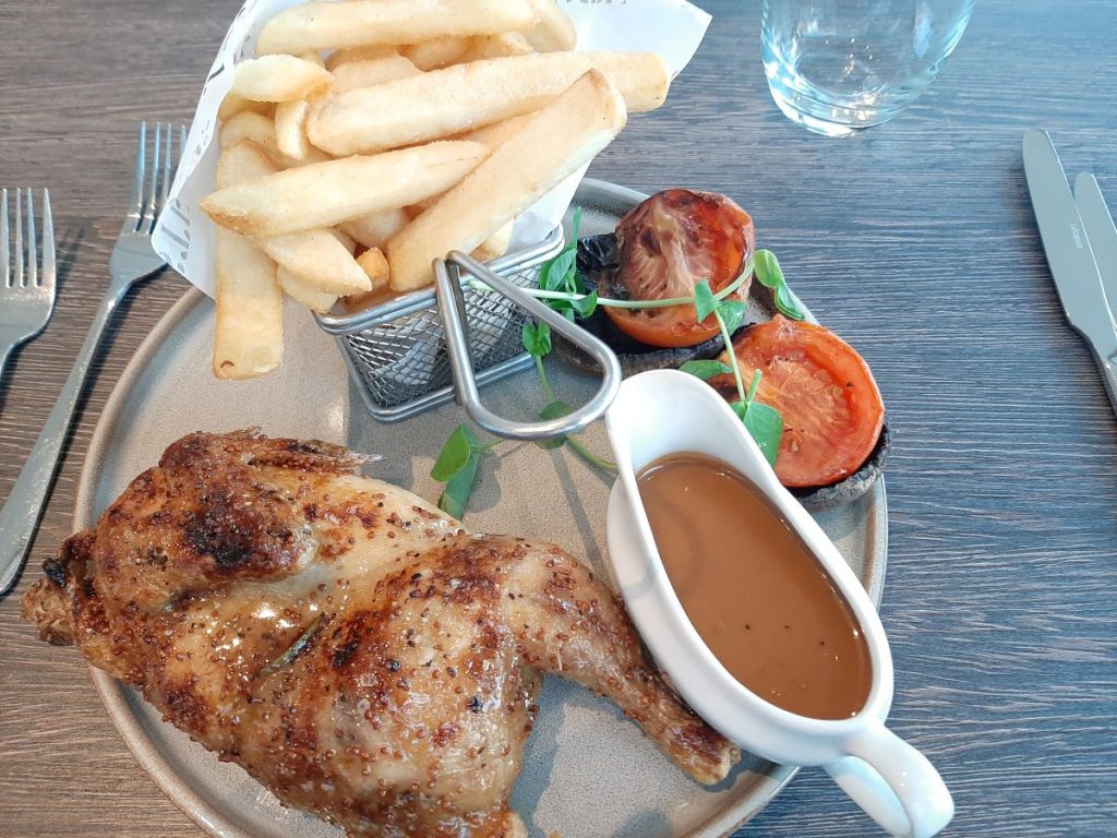 Chicken with maple and mustard glaze served with grilled Portobello mushroom, roasted plum tomato and chunky chips at the Hilton London Wembley.